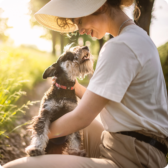 Woman smiling at her dog outdoors