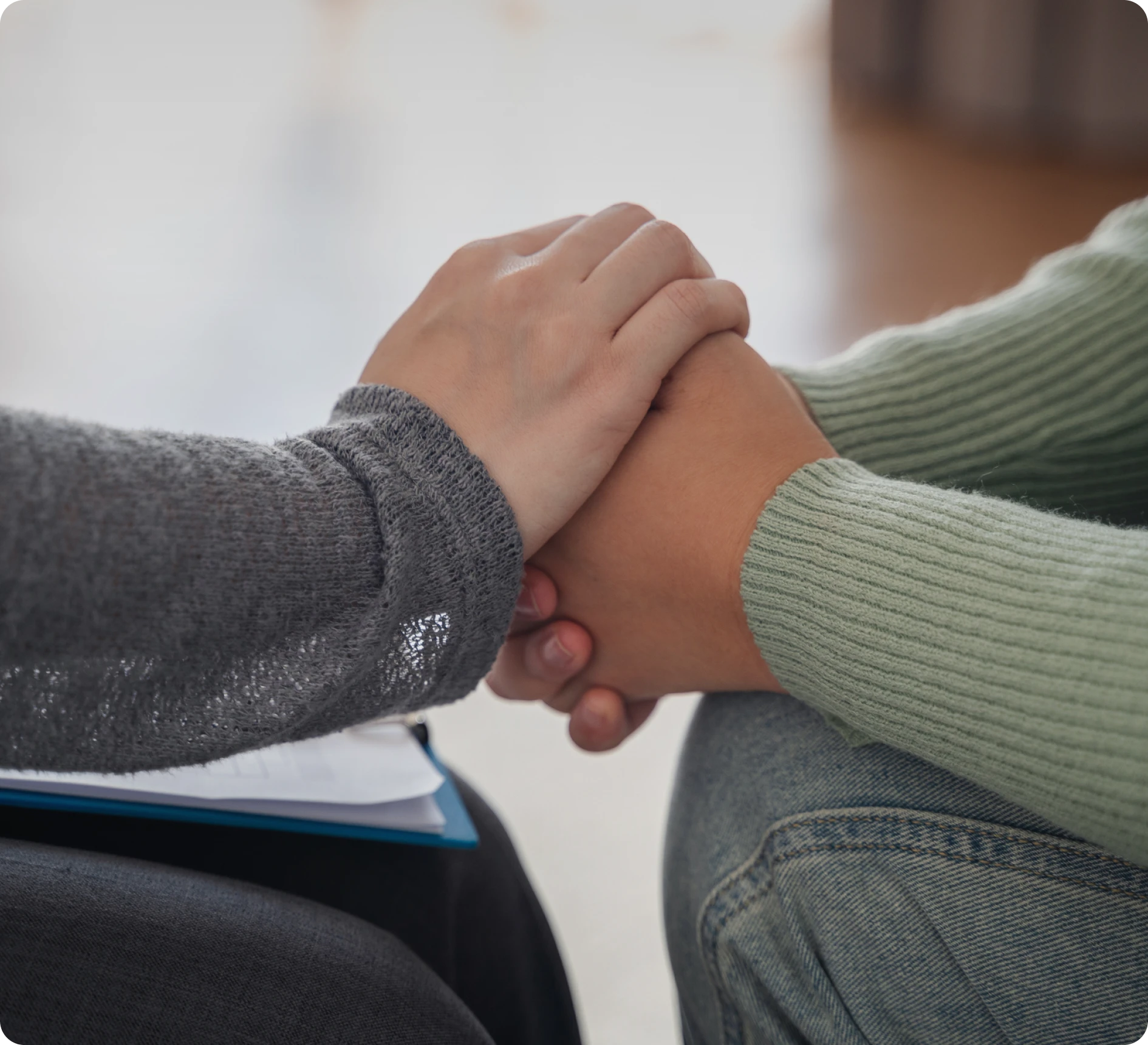 Two people holding hands supportively